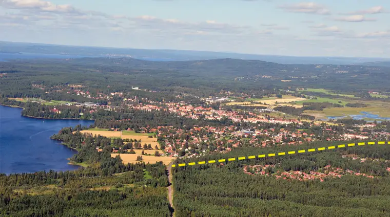 Flygbild över centrala Leksand, tagen söderifrån med Österviken i vänster kant. Moskogsvägens tänkta sträckning är markerad på bilden